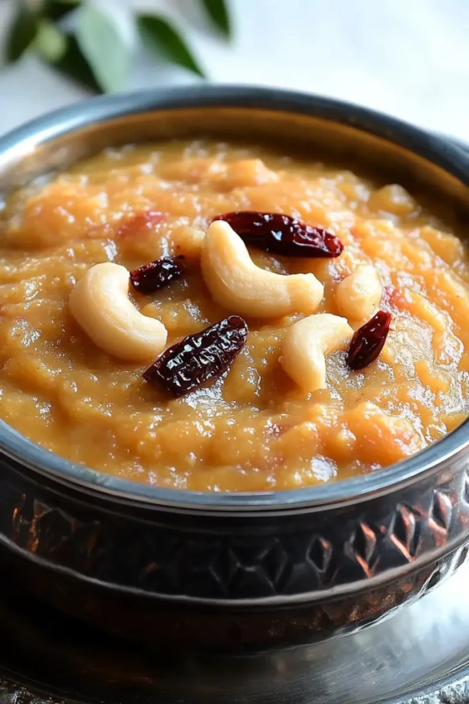 A golden bowl of Sakkarai Pongal, topped with roasted nuts and dried fruits.