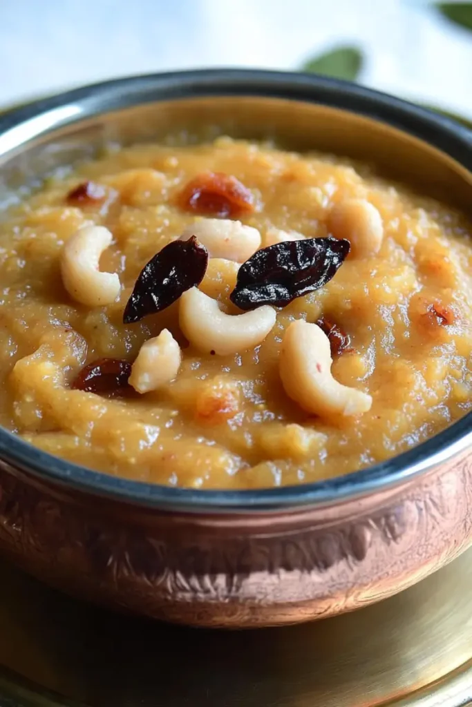 Sakkarai Pongal in a silver bowl with fresh garnishes of cashews and chilies.