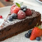 Moist gluten free chocolate cake slice topped with berries